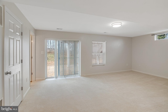 spare room with light carpet, visible vents, and baseboards