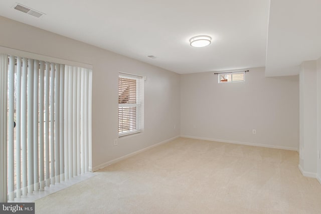 empty room featuring carpet, visible vents, and baseboards