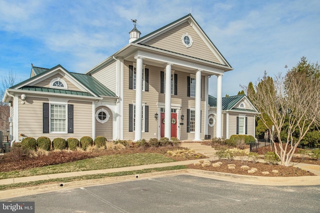 neoclassical / greek revival house featuring metal roof and a standing seam roof