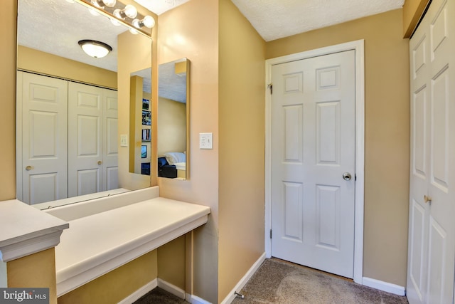 bathroom with baseboards and a textured ceiling