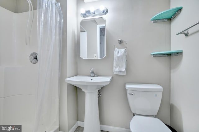 bathroom with a shower with curtain, toilet, and a sink