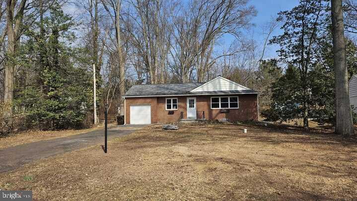 single story home featuring aphalt driveway and an attached garage