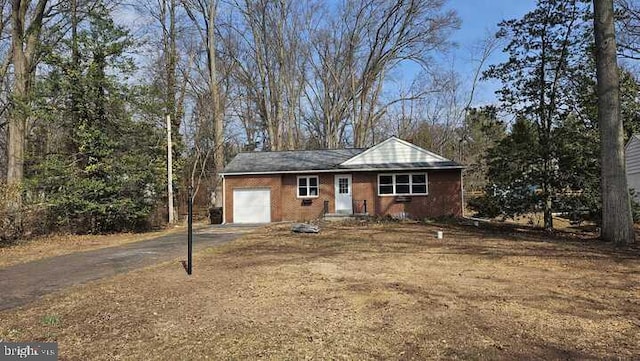 single story home featuring aphalt driveway and an attached garage