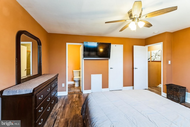 bedroom featuring baseboards, ensuite bath, and dark wood-style flooring