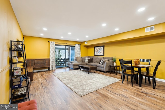 living room with recessed lighting, wood finished floors, and visible vents