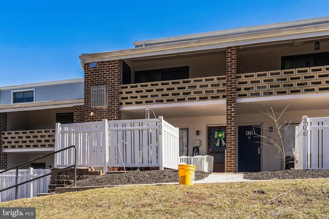 view of front of house featuring stucco siding and fence