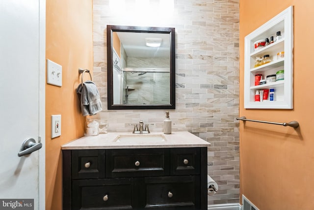 bathroom with vanity, an enclosed shower, visible vents, and backsplash