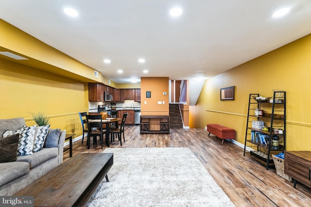 living area featuring visible vents, recessed lighting, light wood finished floors, baseboards, and stairs