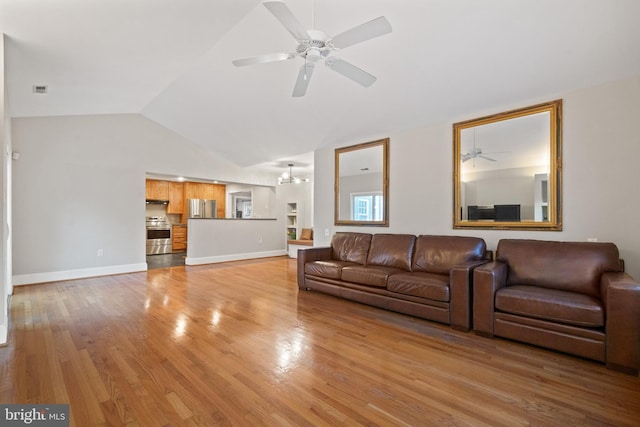 living room with baseboards, lofted ceiling, ceiling fan, and light wood finished floors