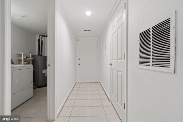 hallway featuring light tile patterned floors, visible vents, washer / dryer, and electric water heater