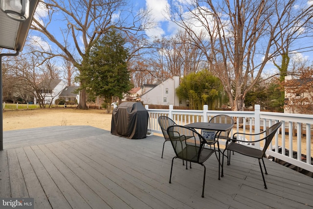 wooden terrace featuring outdoor dining area and grilling area