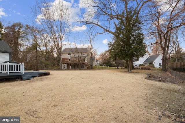 view of yard with a wooden deck, stairs, and fence