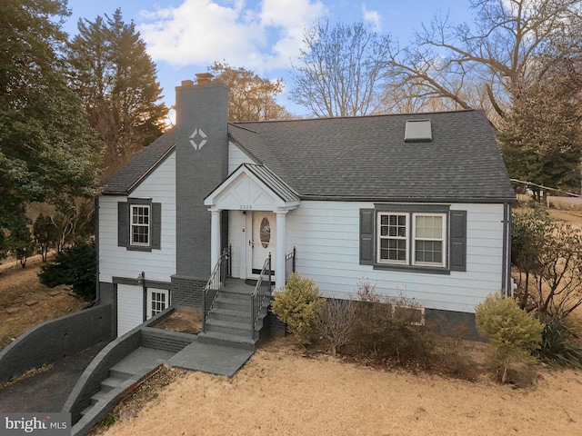 view of front of house with a chimney and a shingled roof