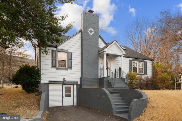 view of front of home with roof with shingles and a chimney