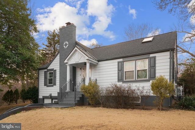 bungalow-style home with a chimney and a shingled roof