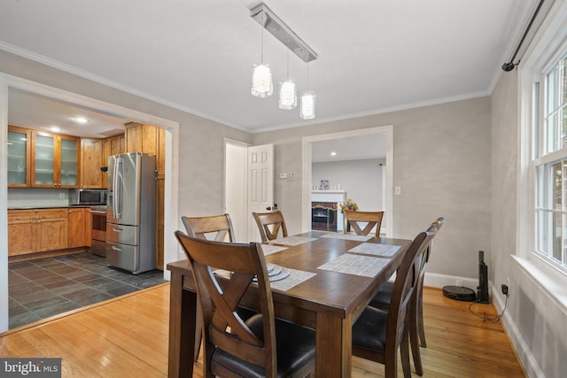 dining room featuring ornamental molding, an inviting chandelier, baseboards, and dark wood-style flooring