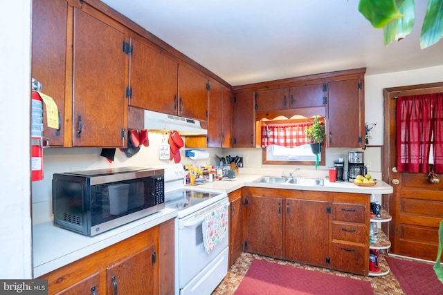 kitchen featuring white electric stove, a sink, light countertops, under cabinet range hood, and stainless steel microwave