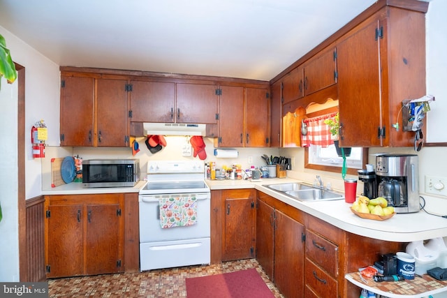 kitchen featuring stainless steel microwave, under cabinet range hood, light countertops, white electric range oven, and a sink