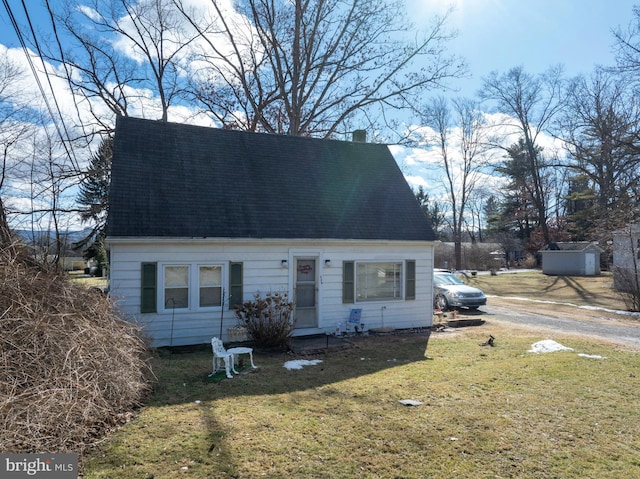 cape cod home with a front lawn and a chimney