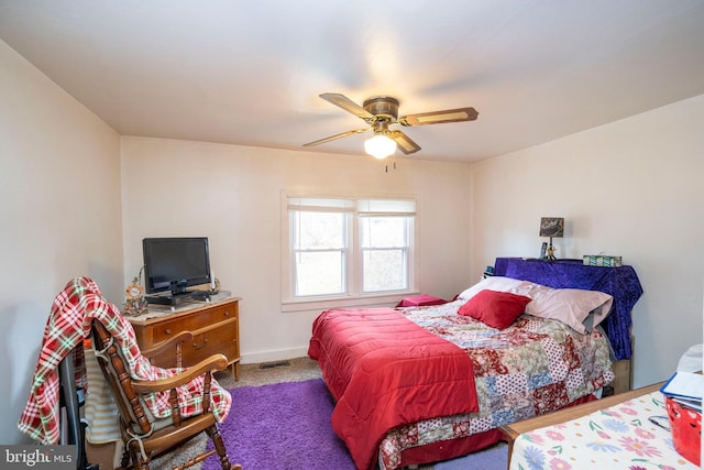 carpeted bedroom featuring baseboards, visible vents, and ceiling fan