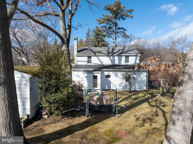 rear view of house with a lawn and a chimney