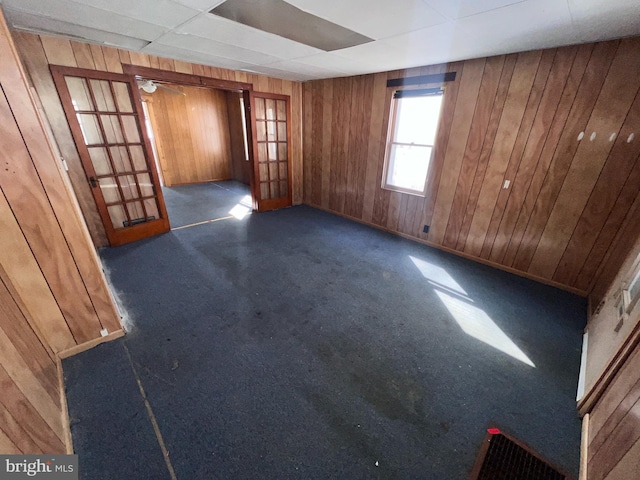 unfurnished room with wooden walls and french doors