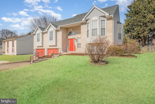 split foyer home featuring driveway, brick siding, and a front yard