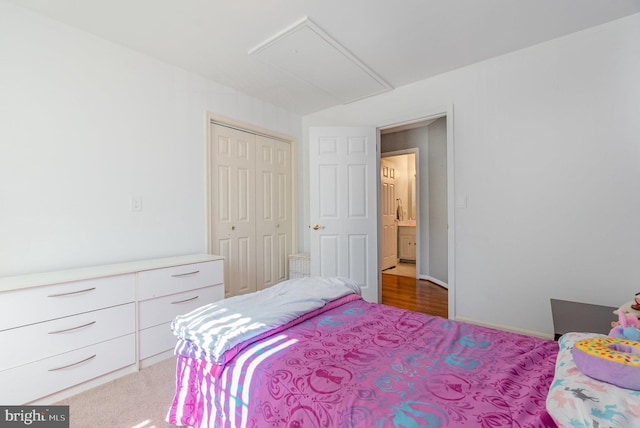 carpeted bedroom featuring a closet, attic access, and baseboards