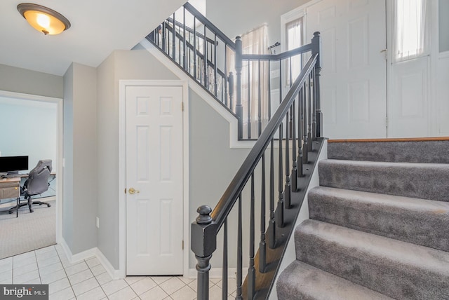 stairway with tile patterned flooring, a healthy amount of sunlight, and baseboards