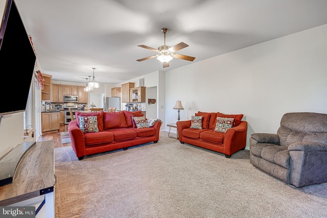 living area with light colored carpet and ceiling fan with notable chandelier