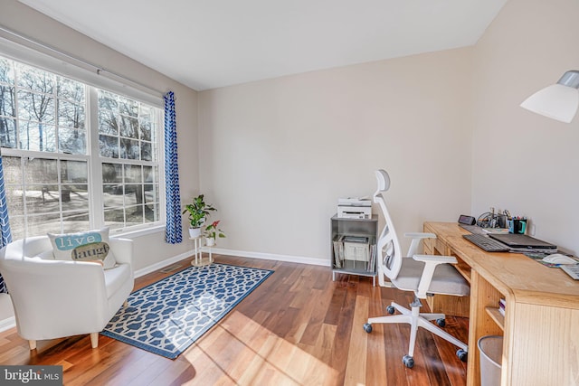 office area with baseboards, a healthy amount of sunlight, and wood finished floors