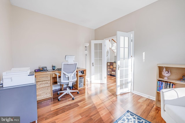 office featuring french doors, baseboards, and light wood finished floors