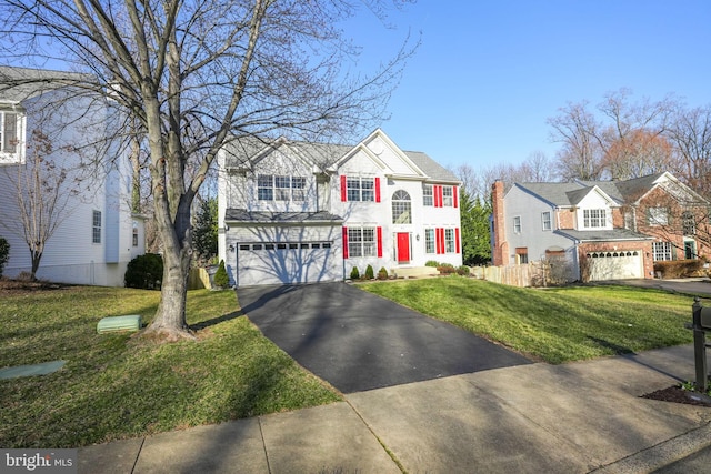 view of front of home featuring aphalt driveway, a front yard, an attached garage, and fence