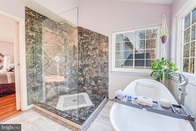 ensuite bathroom featuring a soaking tub, plenty of natural light, a shower stall, and connected bathroom