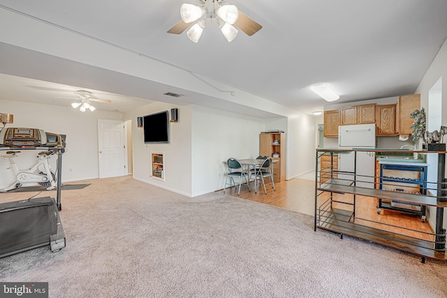 workout room featuring light carpet, visible vents, baseboards, and a ceiling fan