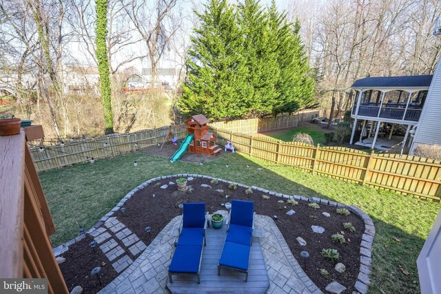 view of yard featuring a patio area, a fenced backyard, and a playground