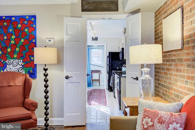 interior space with baseboards and brick wall