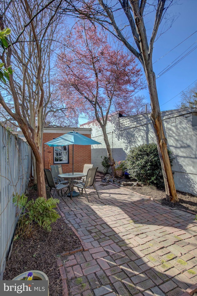 view of patio featuring an outdoor structure and a fenced backyard