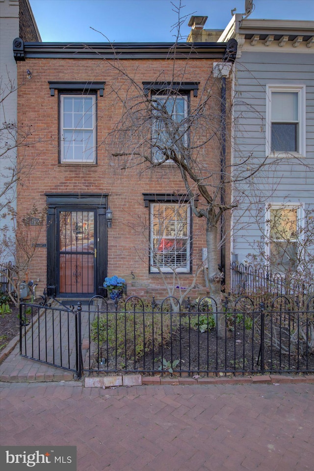 view of front of house featuring brick siding and a fenced front yard