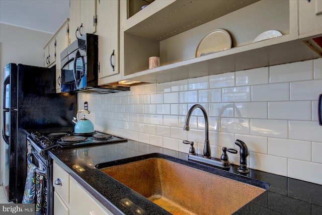 kitchen featuring a sink, backsplash, black microwave, and electric range oven