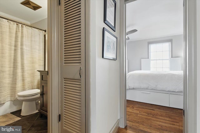 full bathroom featuring toilet, ornamental molding, ensuite bathroom, wood finished floors, and a closet