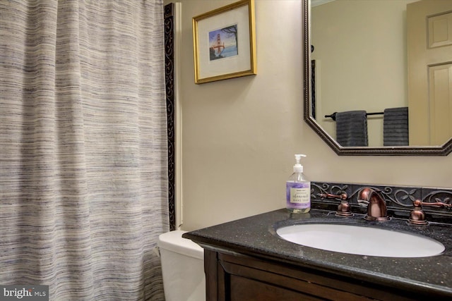 full bathroom featuring toilet, curtained shower, and vanity