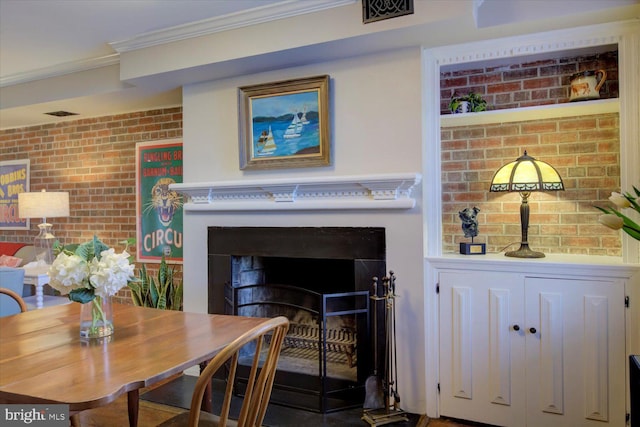 dining space featuring a fireplace, brick wall, and ornamental molding