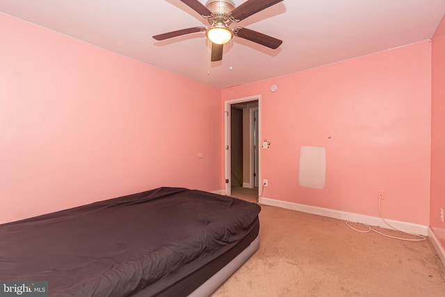 unfurnished bedroom featuring ceiling fan, baseboards, and light carpet