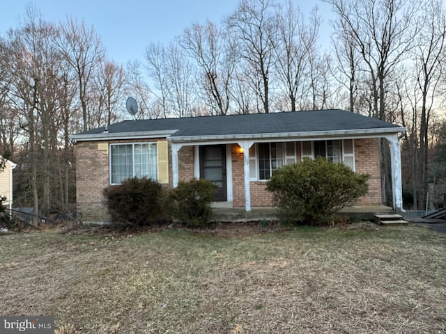 ranch-style house with a front lawn, brick siding, and covered porch