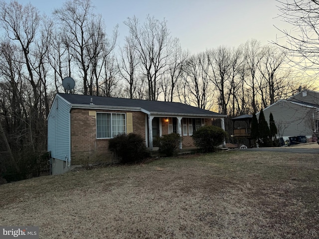 view of front of property featuring brick siding and a front lawn