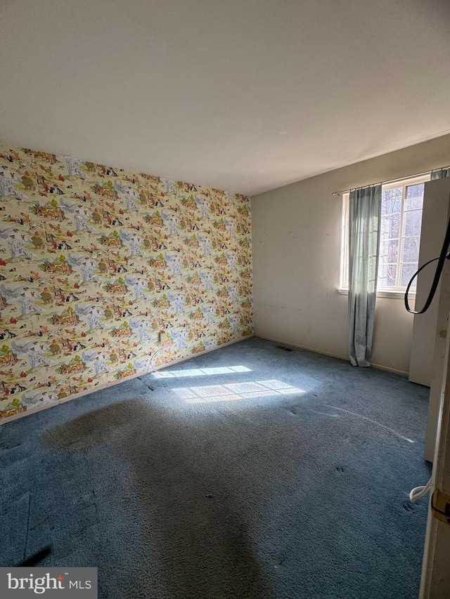 carpeted empty room with wallpapered walls