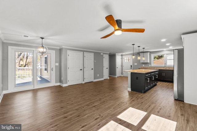 kitchen featuring a kitchen island, wood finished floors, ornamental molding, and freestanding refrigerator