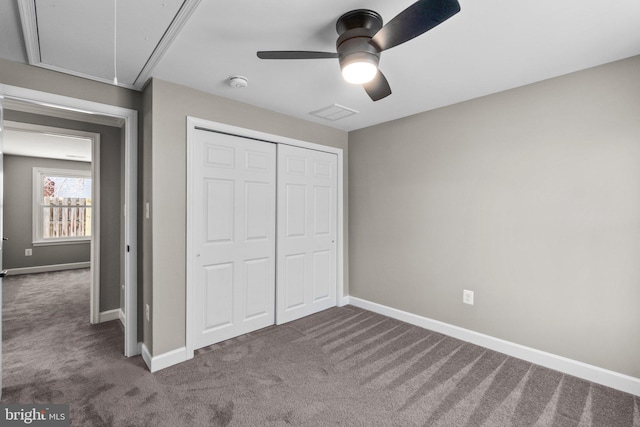 unfurnished bedroom with attic access, a closet, baseboards, and carpet floors