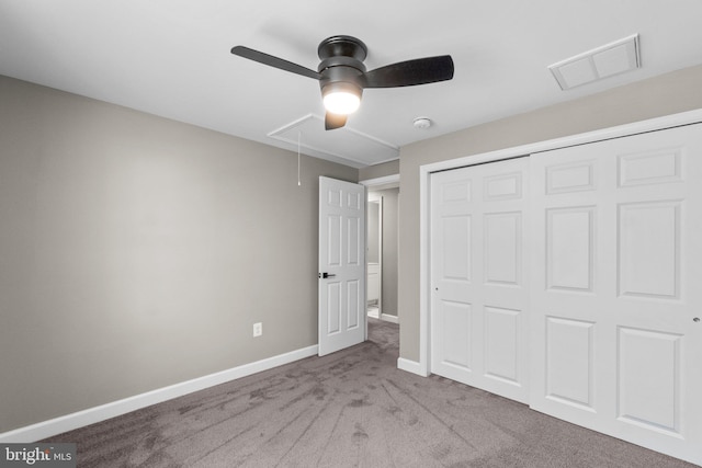 unfurnished bedroom featuring visible vents, baseboards, carpet, attic access, and a closet